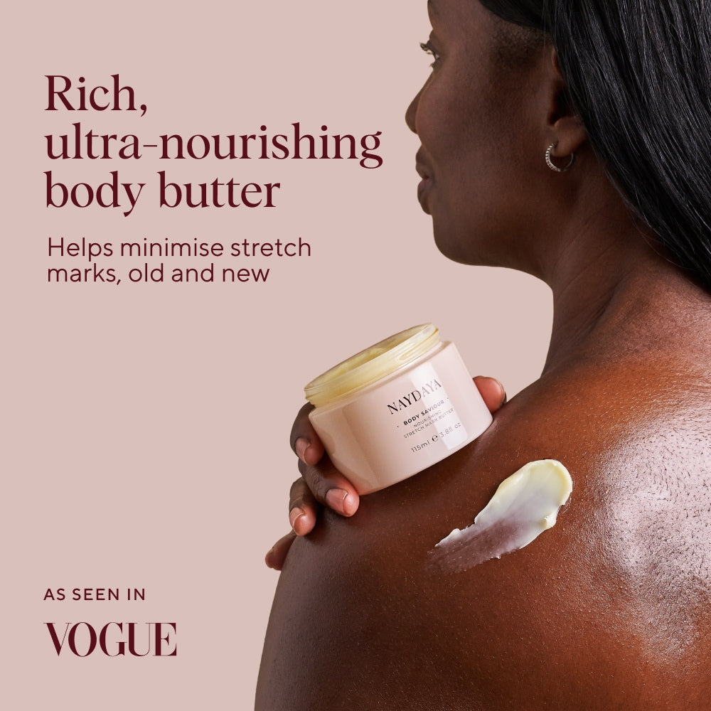 A woman in profile holds a jar of Naydaya Rich Ultra-Nourishing Body Saviour Butter against a warm beige background, with a smear of the cream visible on her shoulder. Text on the image highlights the product benefits, and 'AS SEEN IN VOGUE' appears in the lower left.