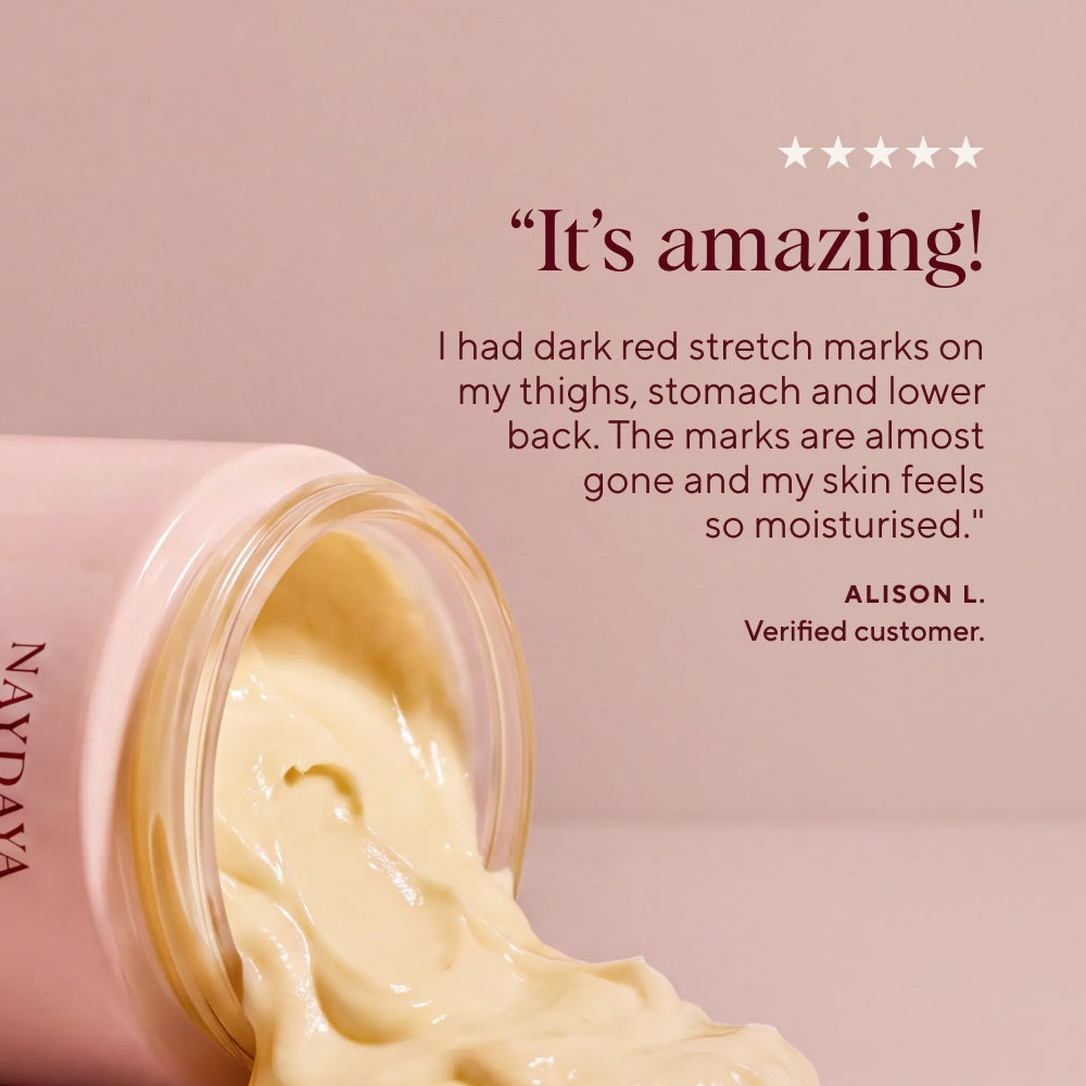 A pink jar of NAYDAYA Body Saviour cream balm with pale yellow product spilling out, set against a soft pink background with a customer testimonial quote and five stars.