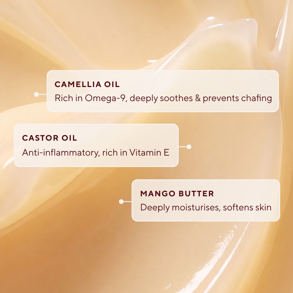 Close-up of a creamy beige skincare product with three text callouts highlighting the ingredients of Naydaya's Breast Saviour Nipple Balm, reading 'CAMELLIA OIL,' 'CASTOR OIL,' and 'MANGO BUTTER' over a soft, glossy cream background.