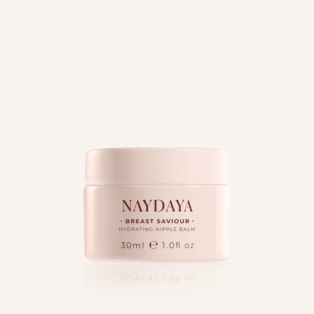 A pale pink jar of NAYDAYA Breast Saviour Hydrating Nipple Balm, centered on a clean off-white background with a subtle reflection below.