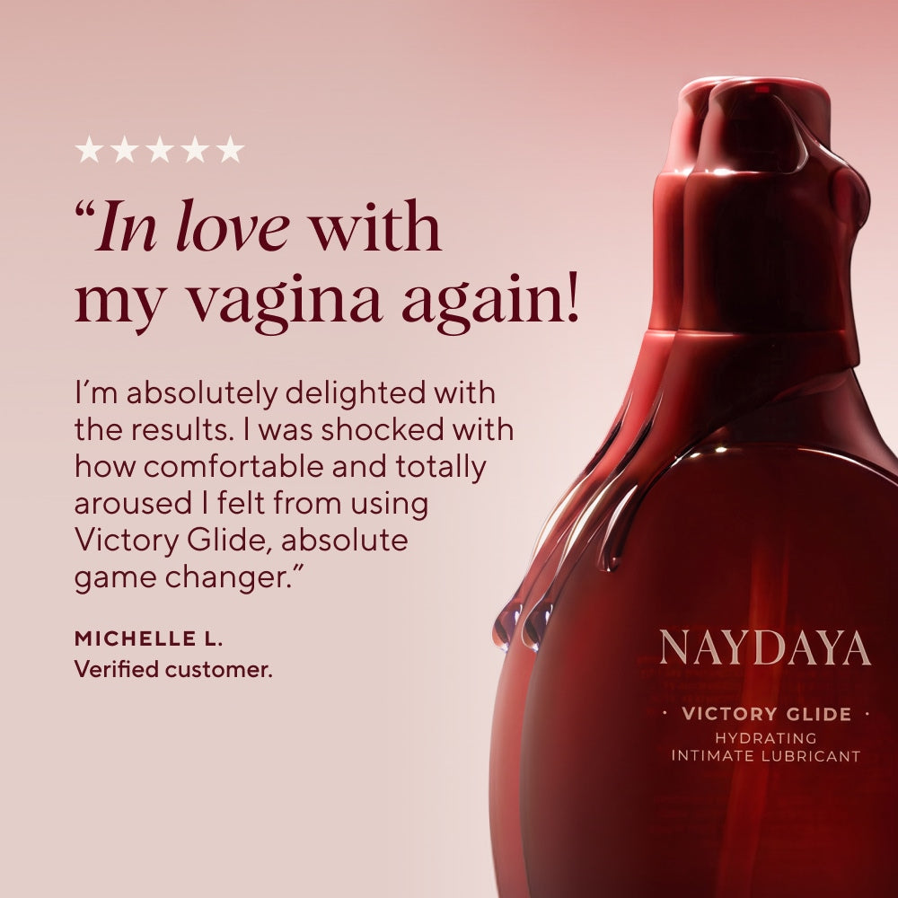 A bottle of NAYDAYA Victory Glide hydrating intimate lubricant shown on a soft pink background with a customer review quote on the left.